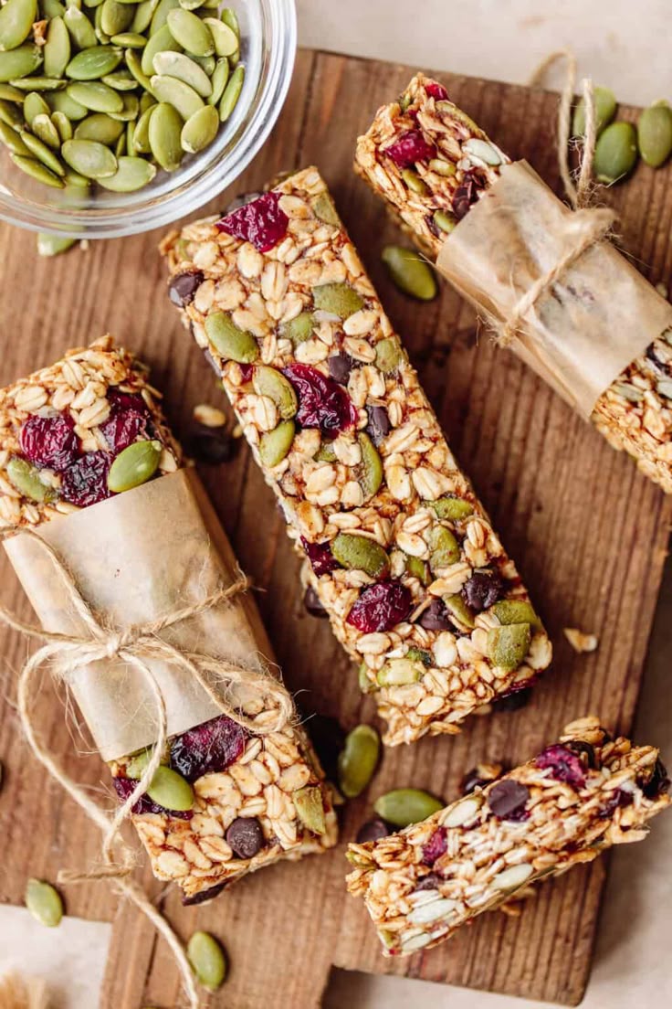 This may contain: homemade granola bars on a cutting board with nuts and seeds