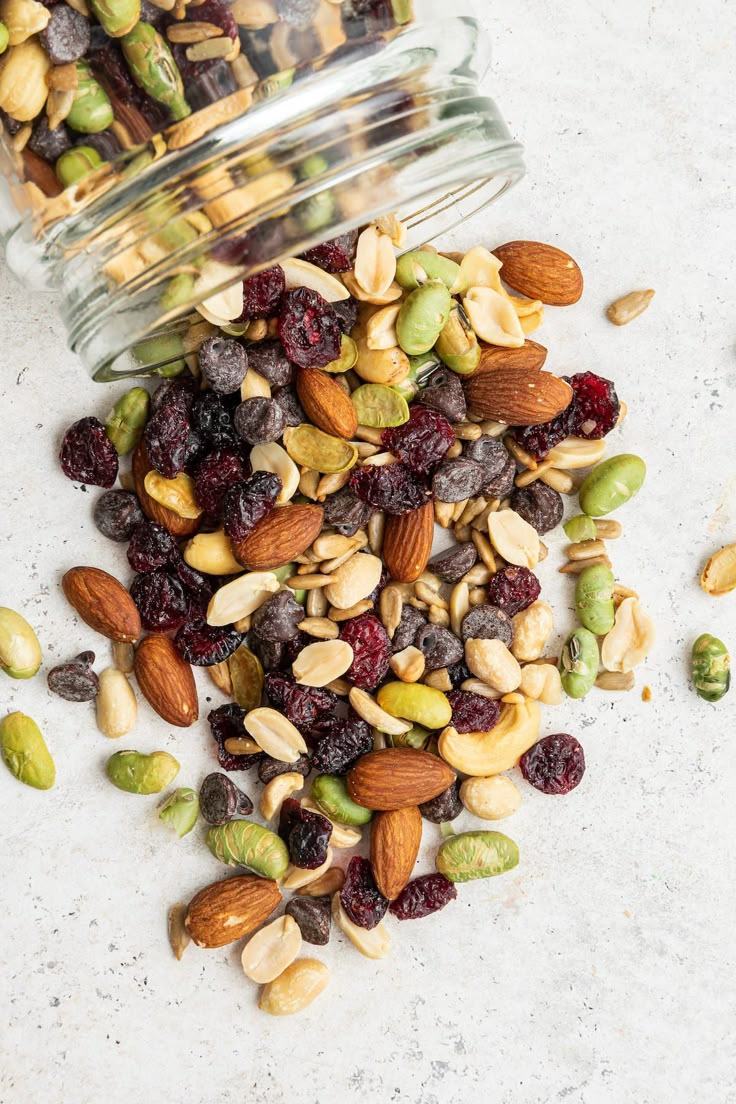 This may contain: mixed nuts and cranberries in a glass jar