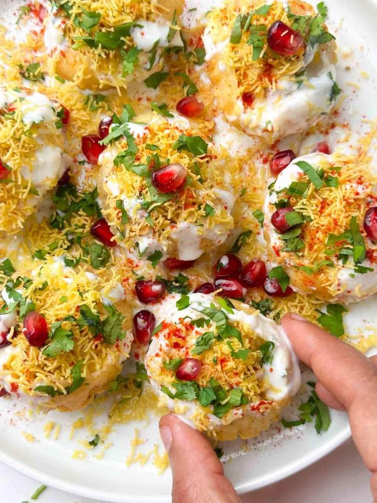 This may contain: a white plate topped with eggs covered in cheese and garnished with pomegranates