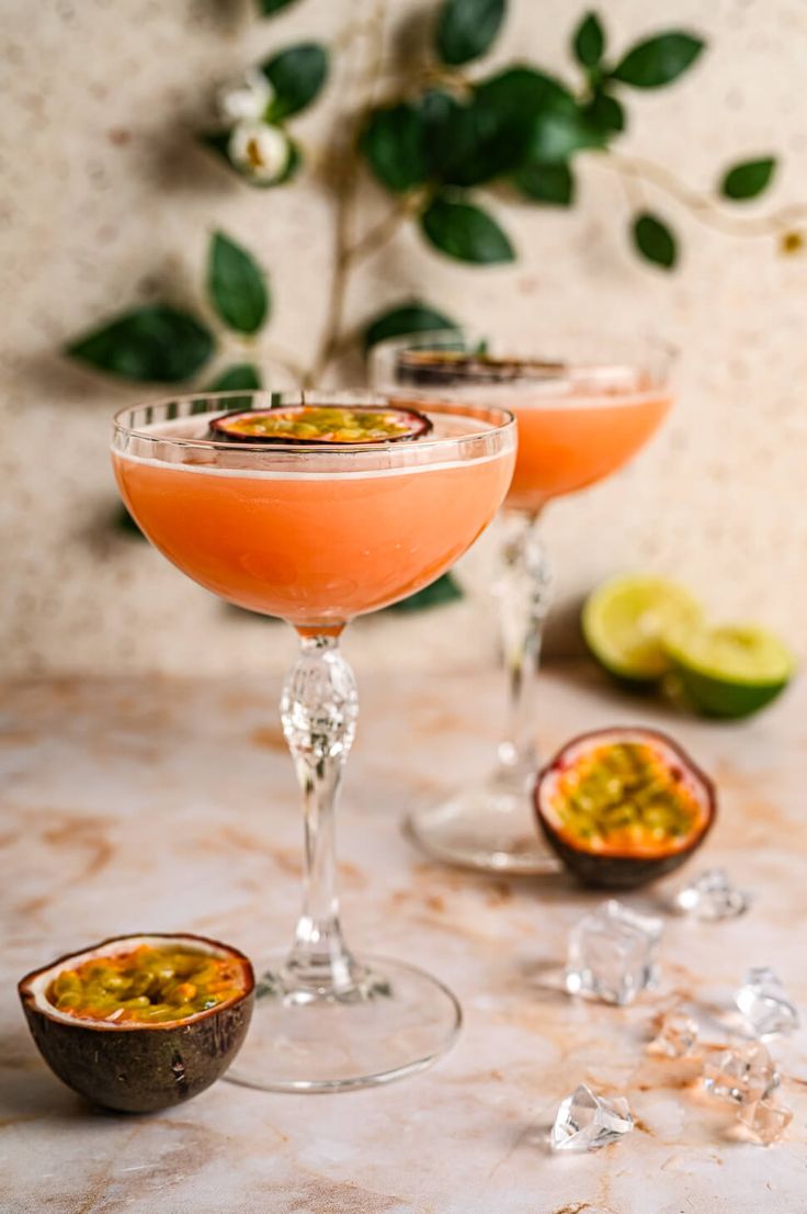 This may contain: two glasses filled with drinks sitting on top of a table