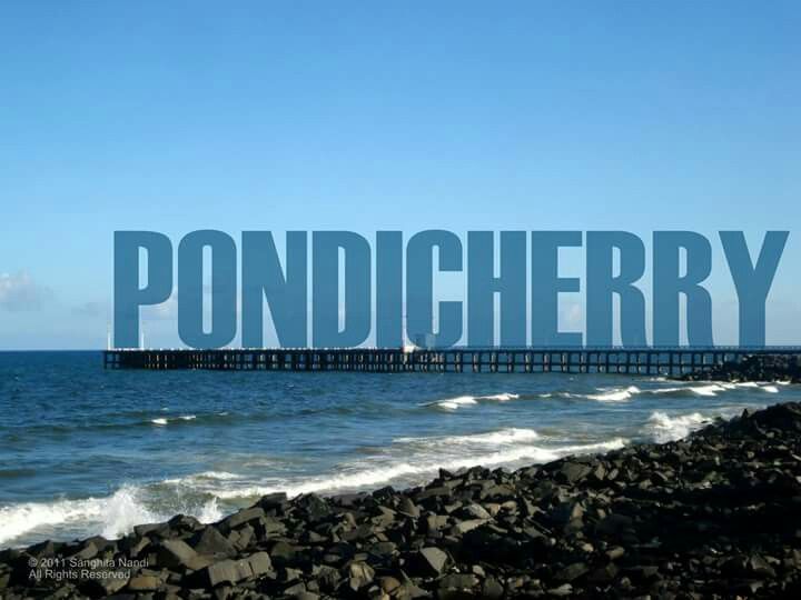 This may contain: the word pondcherry is written in front of an ocean with rocks and waves