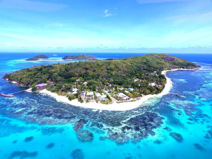 This may contain: an island in the middle of some blue water