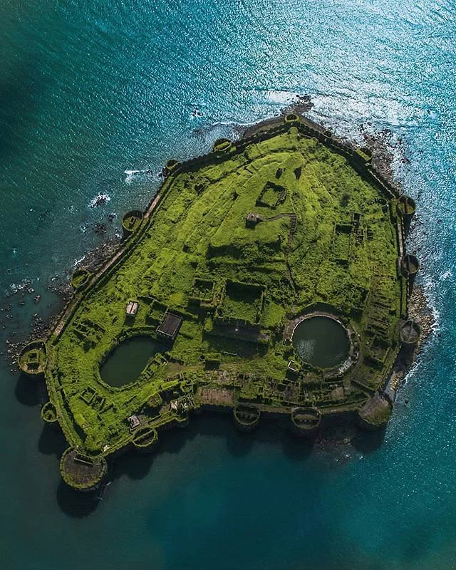 This may contain: an aerial view of the island in the middle of the ocean with water surrounding it