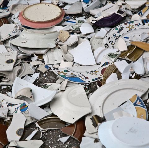 This may contain: a pile of broken plates sitting on top of a floor