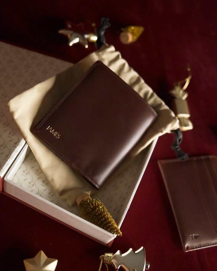 This may contain: an open brown leather book sitting on top of a table next to other items and decorations