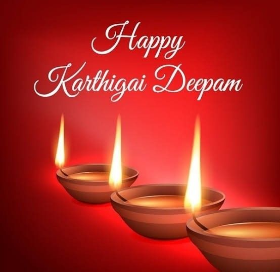 This may contain: three lit candles with the words happy kartingai deepam