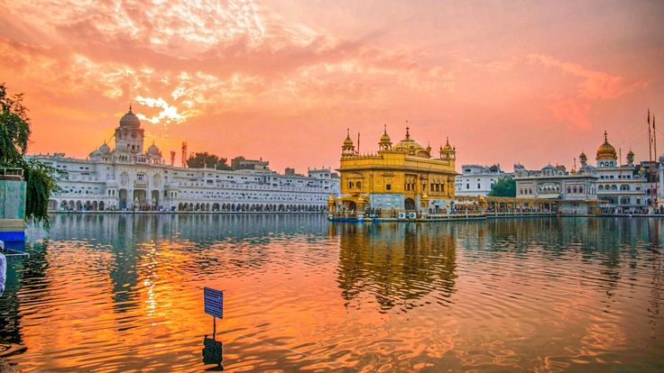 This may contain: the golden temple in amrit, india is reflected in the still water at sunset