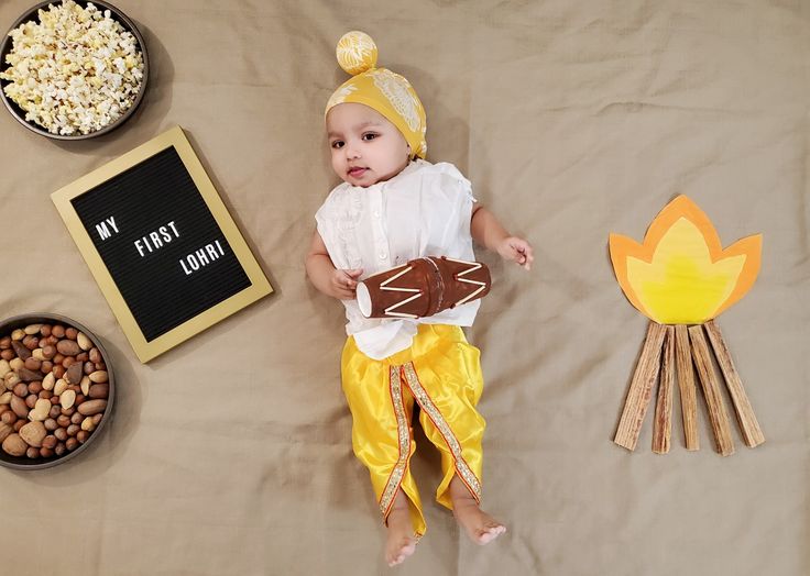 This may contain: a baby is laying on a bed with food and decorations around it, including marshmallows