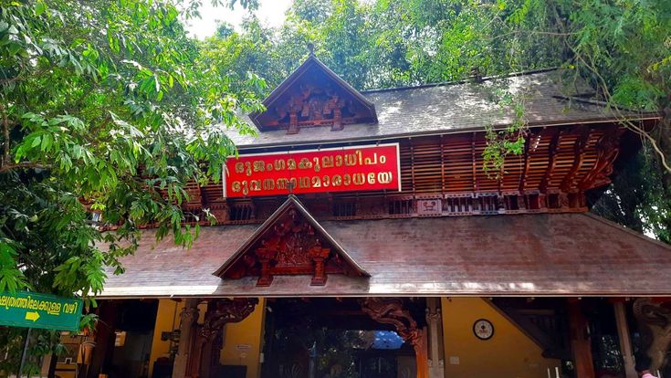 This may contain: a building that has some red signs on the side of it in front of trees