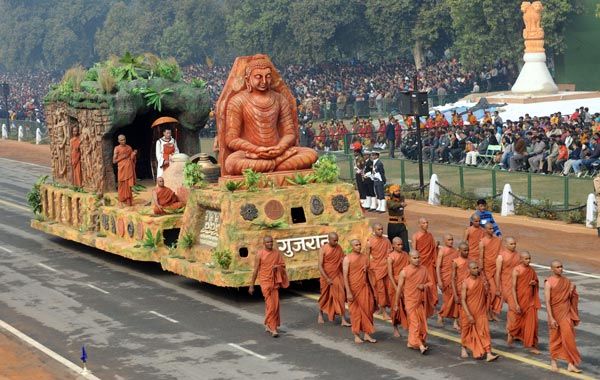 This may contain: a group of people in orange outfits riding on the back of a float down a street
