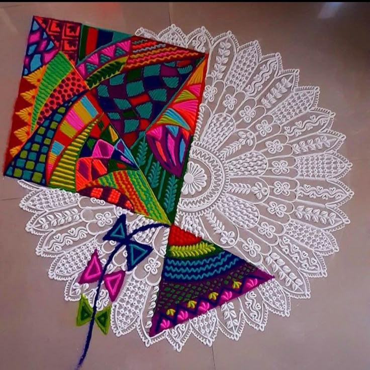 This may contain: a colorful kite is laying on the floor next to it's lace doily