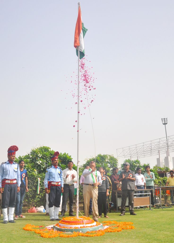 This may contain: men in uniform standing around a flag pole with confetti falling from the top