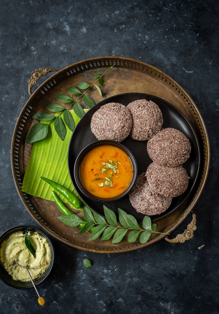 This may contain: some food is sitting on a plate with sauces and green leaves next to it