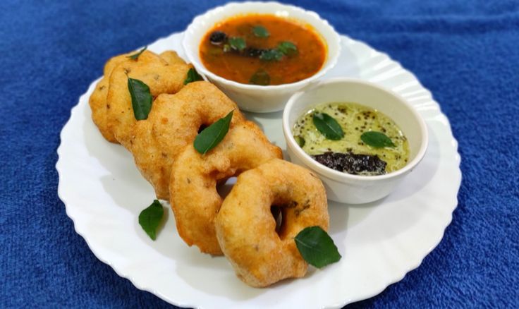 This may contain: some fried food on a white plate with dipping sauces