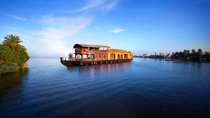 This may contain: a houseboat floating on top of a lake next to trees and water with blue sky