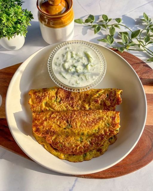 This may contain: an omelet is served on a plate with a side of yogurt