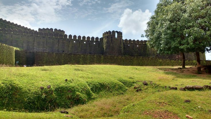 This may contain: an old castle with grass and trees in the foreground