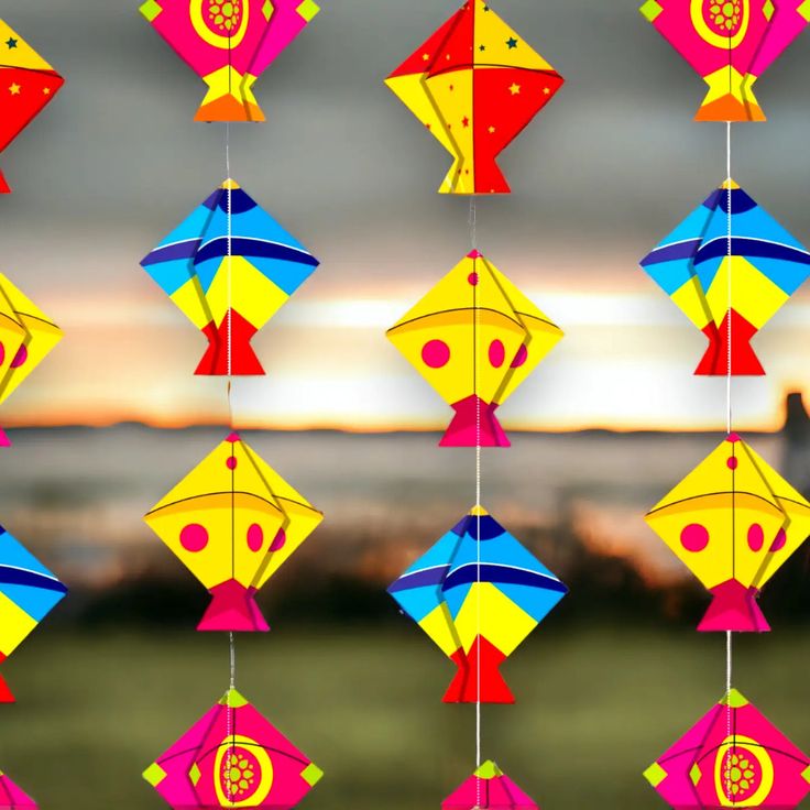 This may contain: several colorful kites hanging from strings on a string