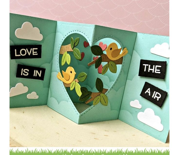 This may contain: an open book with the words love is in the air on it and birds inside