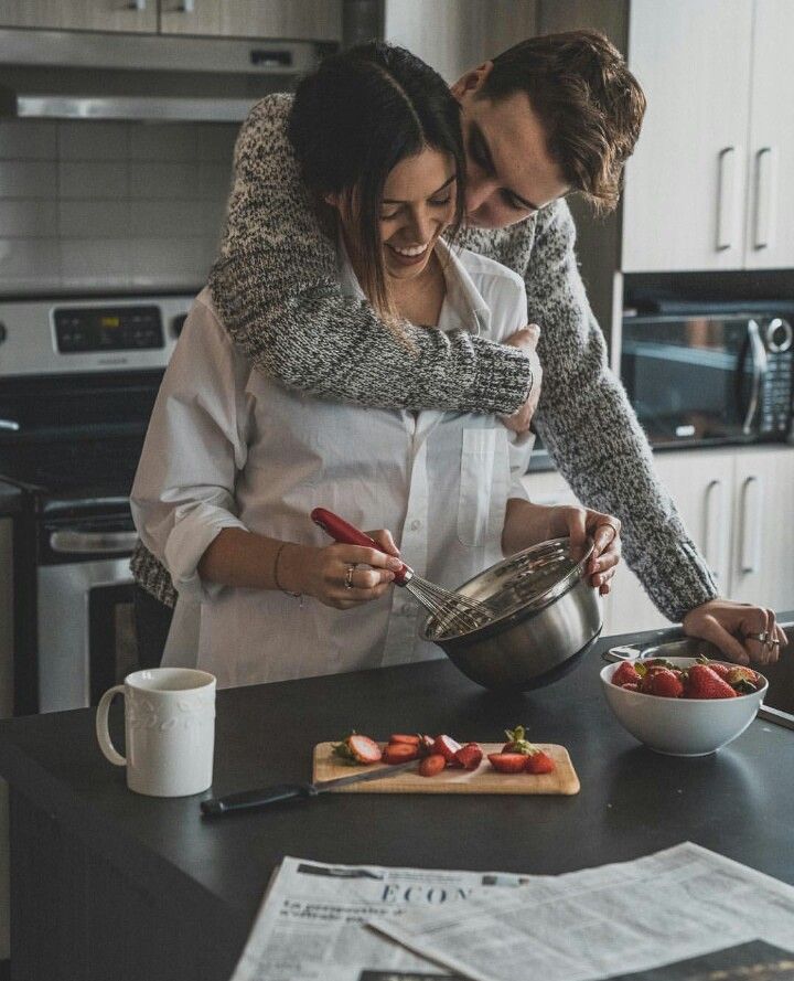 This may contain: a man and woman in the kitchen preparing food on top of a counter next to each other