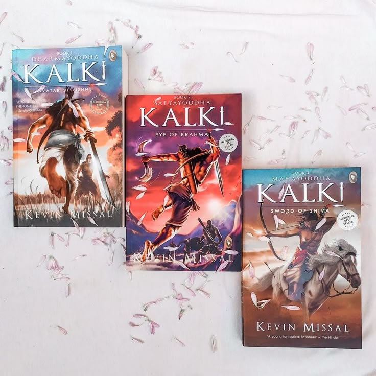 This may contain: three books are laying on the bed together