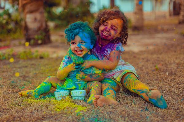 This may contain: two children covered in paint sitting on the ground