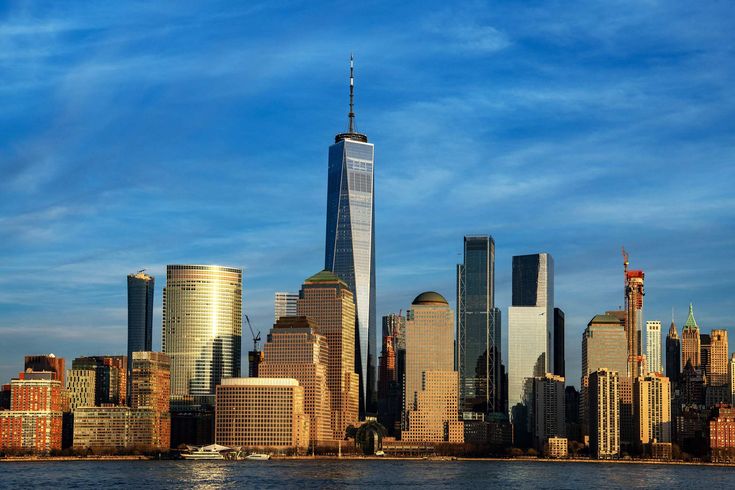 This may contain: the skyline of new york city is seen from across the water with skyscrapers in the background