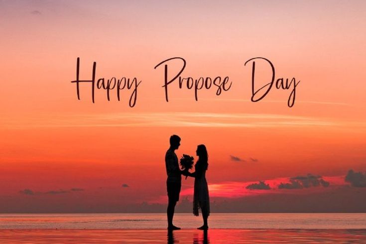 This may contain: two people are standing on the beach at sunset and one is holding a small bouquet