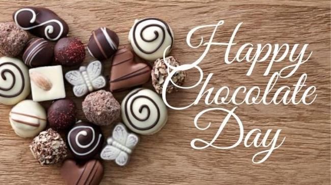 This may contain: chocolates arranged in the shape of a heart on top of a wooden table with words happy chocolate day
