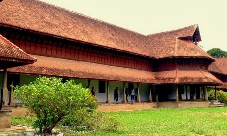 This may contain: an old building with grass and trees in the foreground