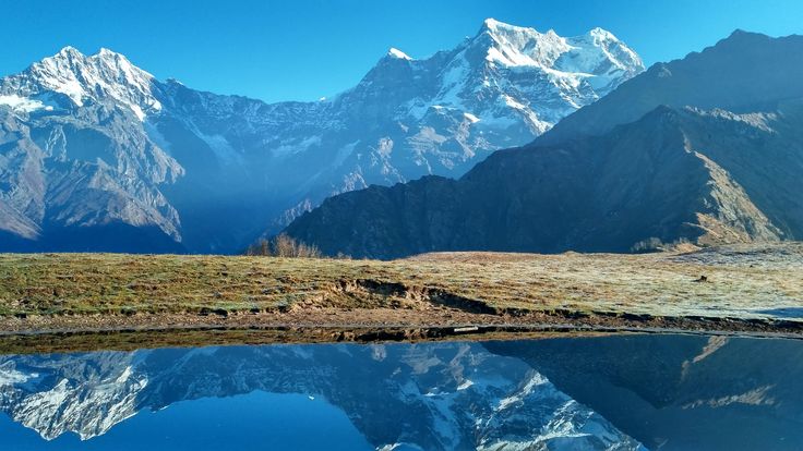 This may contain: the mountains are reflected in the still water