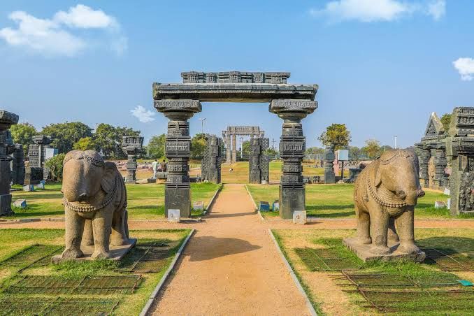 This may contain: statues of elephants in the middle of a grassy area with an archway leading to them