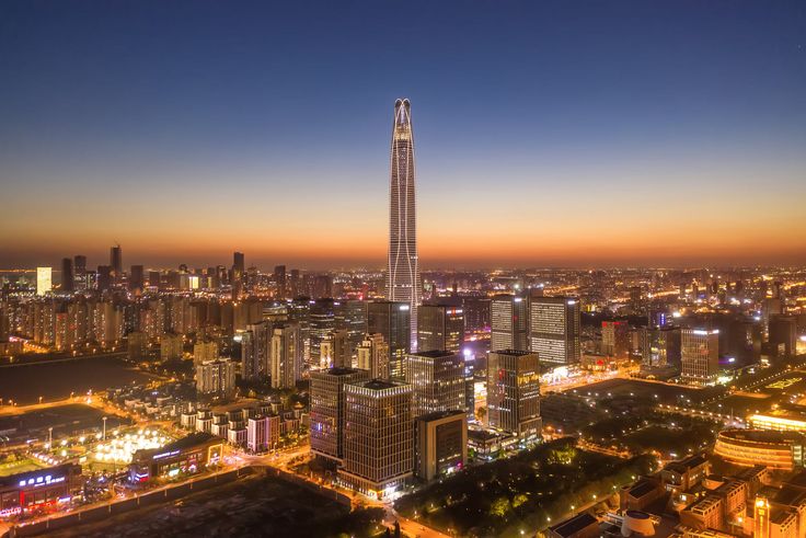 This may contain: an aerial view of a city at night with skyscrapers lit up in the background
