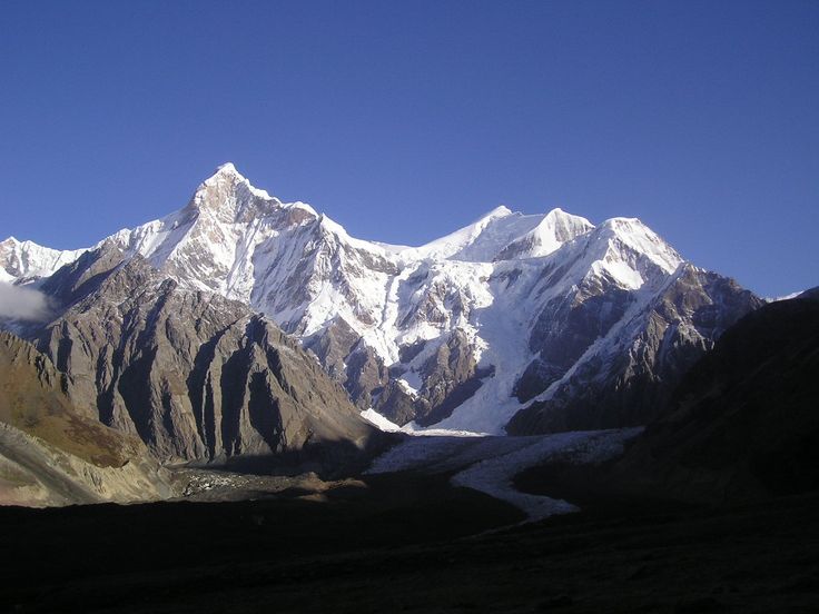 This may contain: the mountains are covered in snow and clouds