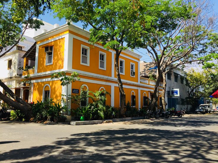This may contain: an orange and white building sitting on the side of a road next to some trees