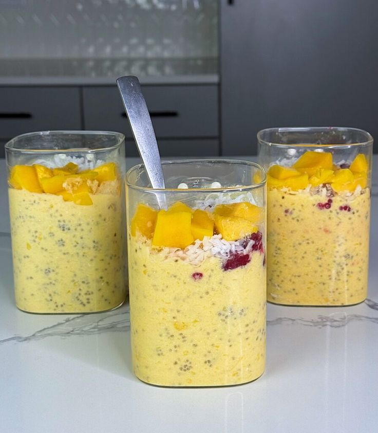 This may contain: three glasses filled with food sitting on top of a counter