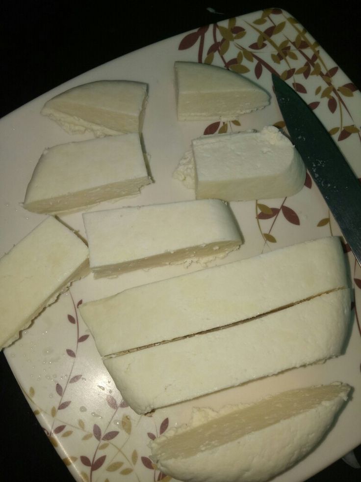 This may contain: slices of cheese on a plate with a knife