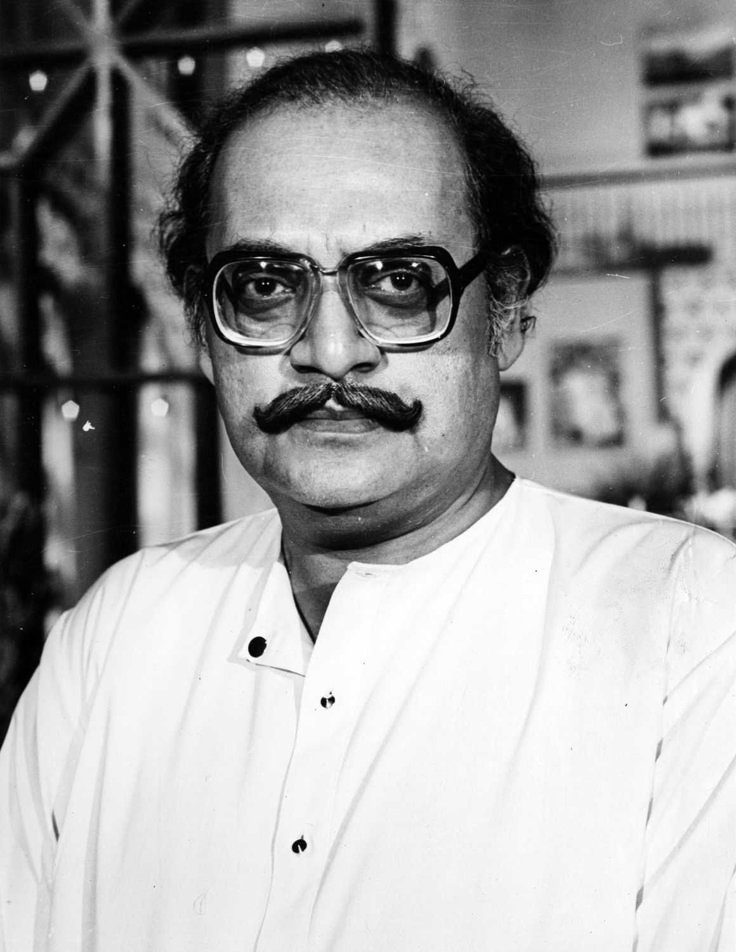 This may contain: black and white photograph of a man wearing glasses with a moustache on his face