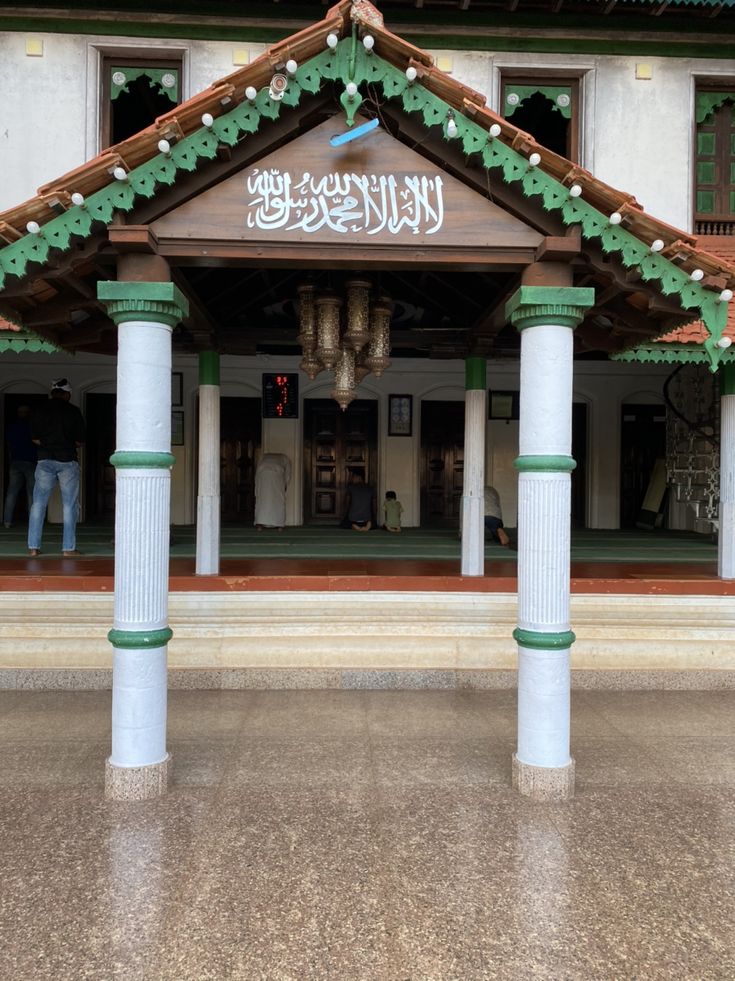 This may contain: a building with pillars and bells in front of it