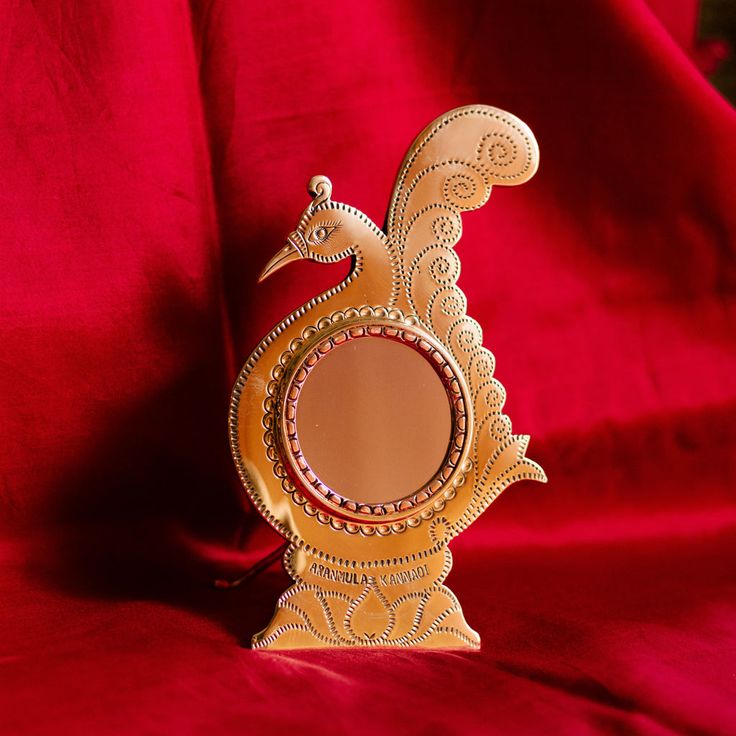 This may contain: a decorative mirror sitting on top of a red cloth