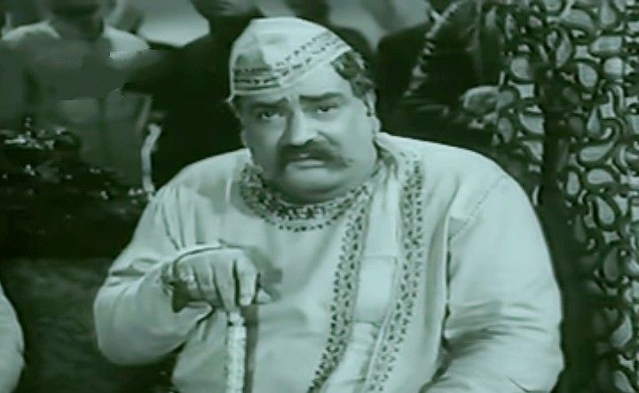 This may contain: an old photo of a man in traditional garb