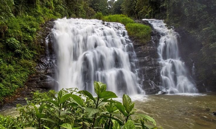 This may contain: a large waterfall with lots of water coming out of it's sides in the jungle