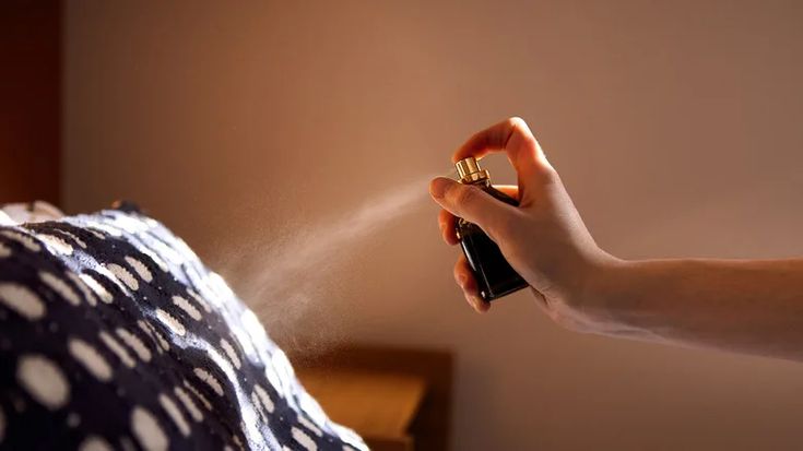 This may contain: a person is spraying something out of their hand with a sprayer on the bed