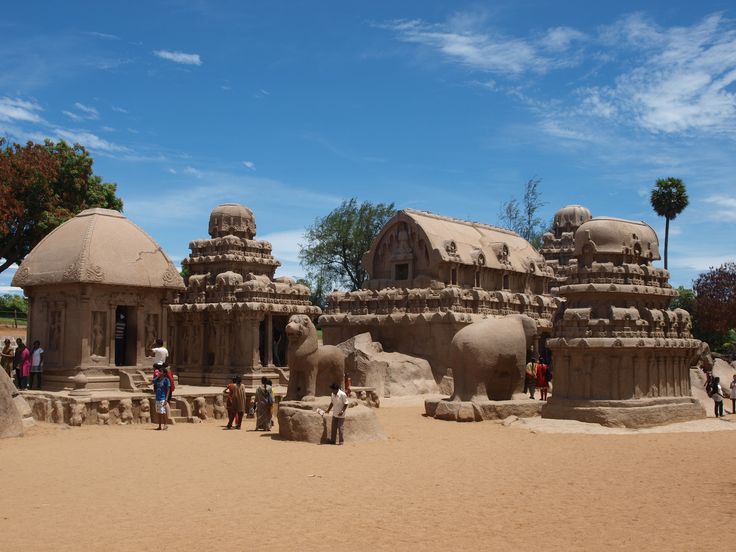 This may contain: people are standing in front of an intricately carved stone structure with elephants and buildings