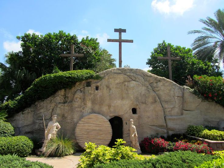 This may contain: there are three statues in front of the entrance to this cave with crosses on it