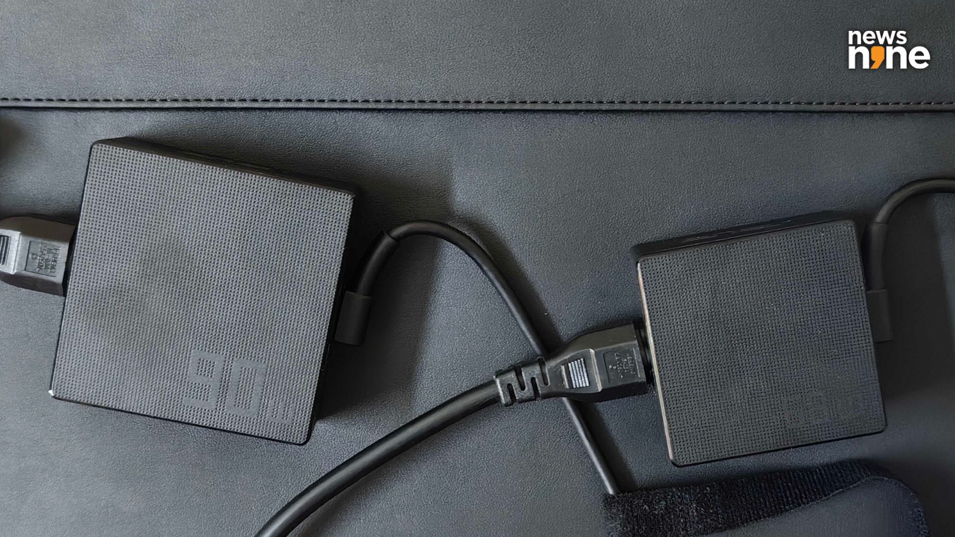 The 90W ExpertBook Ultra charger next to a 68W Zenbook charger, on top of the ExpertBook laptop sleeve. (Image Credit: Aditya Madanapalle/News9). 