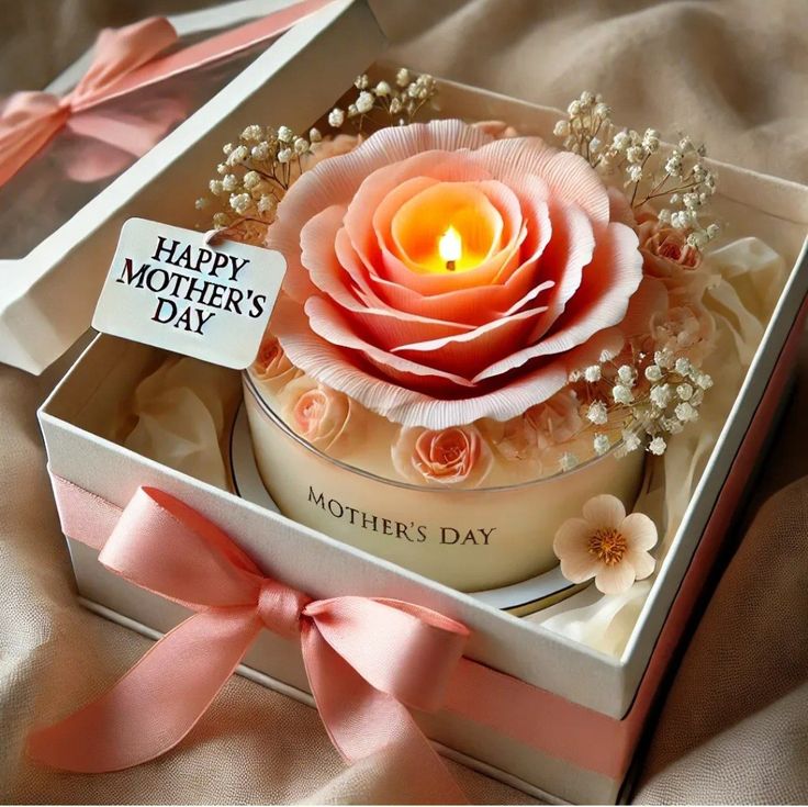 This may contain: a mother's day candle in a gift box with pink ribbon and flowers on it